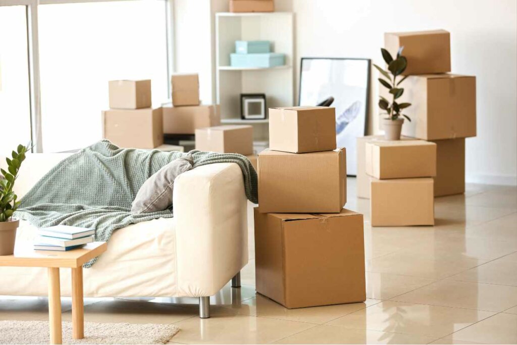  A room with a sofa and cardboard boxes, emphasizing the concept of 'Only keep essentials